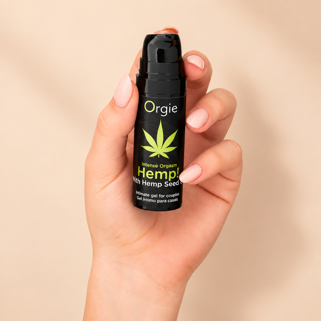 Flacon pompe Orgie Hemp tenu en main, sur fond crème