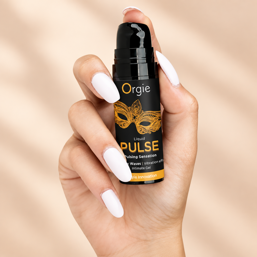 Flacon pompe Orgie Liquid Pulse tenu en main, sur fond crème