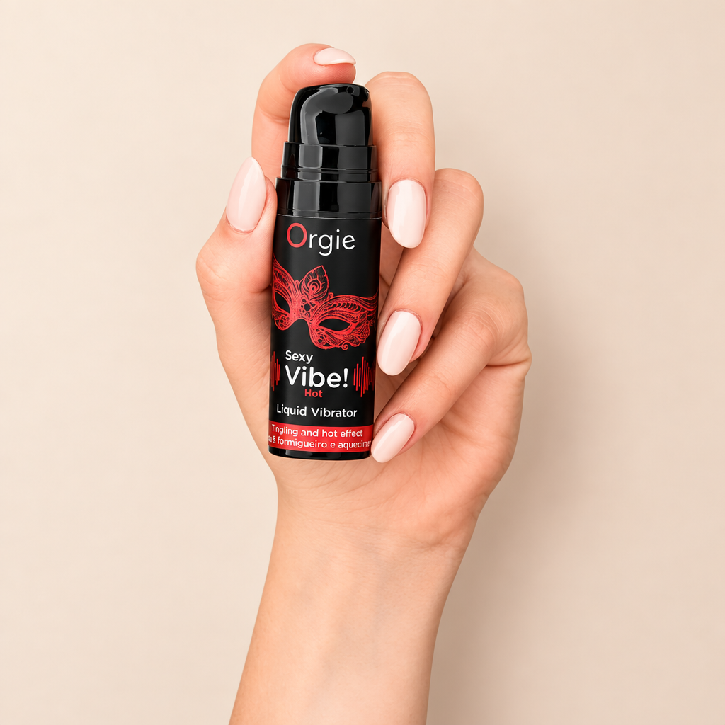 Flacon Orgie Sexy Vibe Hot tenu en main, sur fond crème