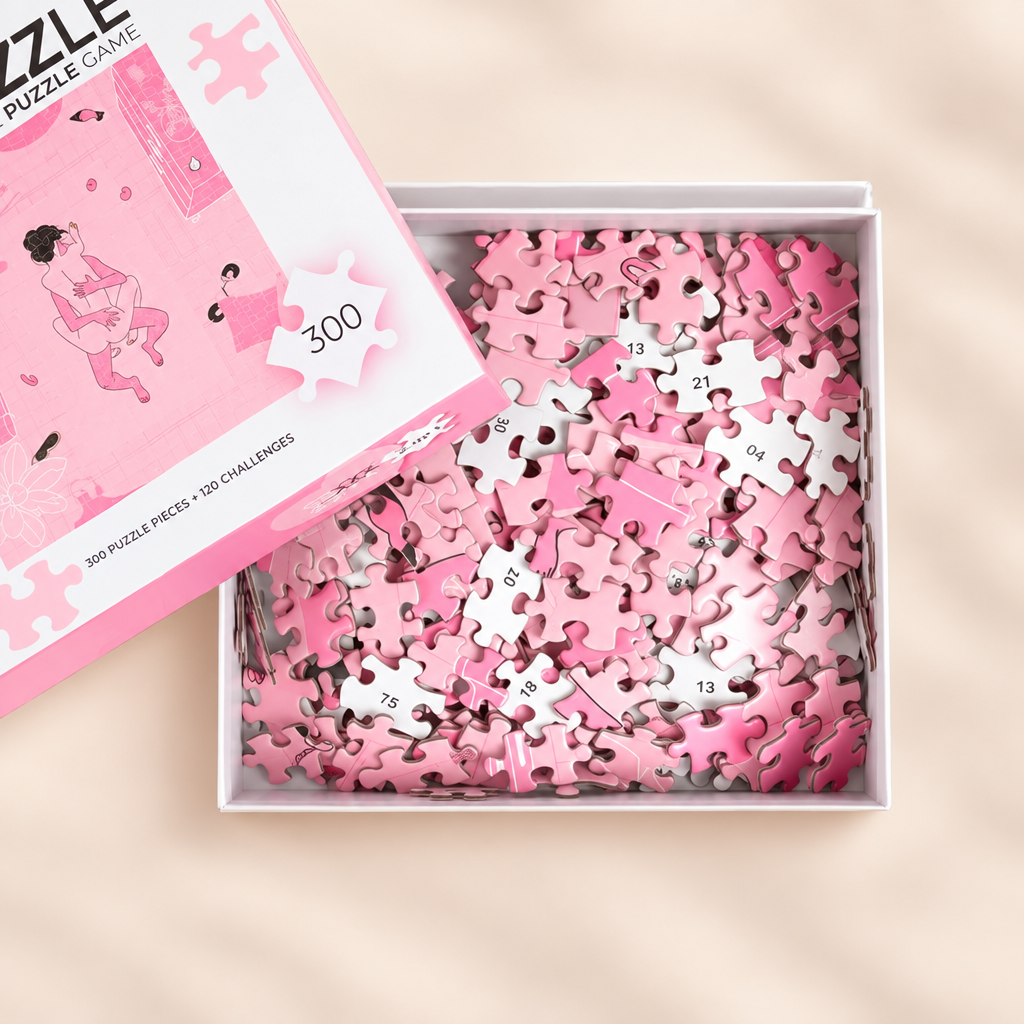Boîte ouverte du puzzle Sexxxzzle avec pièces numérotées, sur fond crème