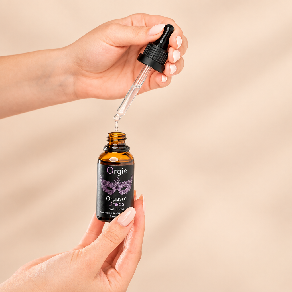 Flacon compte-gouttes Orgie Orgasm Drops tenu en main, sur fond crème